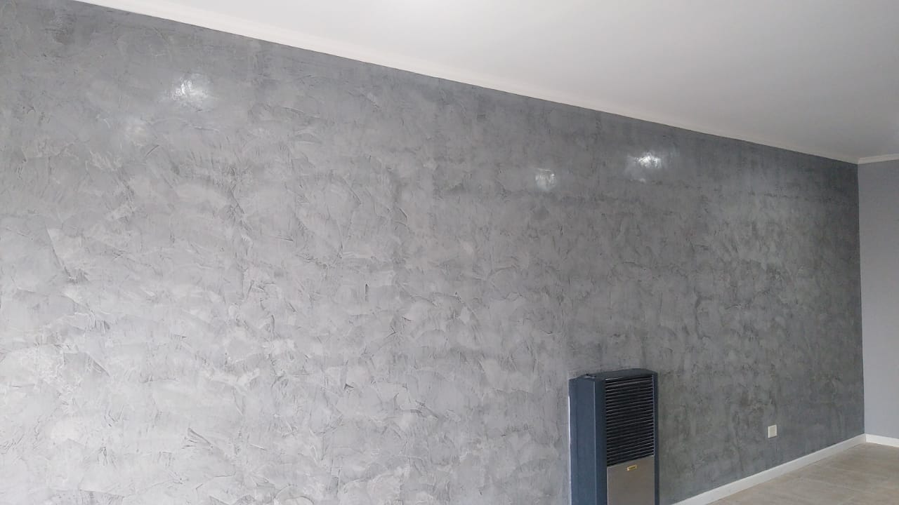 Estucado gris terminado en una pared de sala